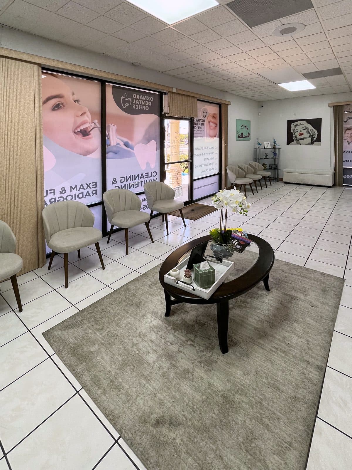 Sala de espera de nuestra oficina, con sillas junto a las ventanas del frente y una mesa de centro con una orquídea.