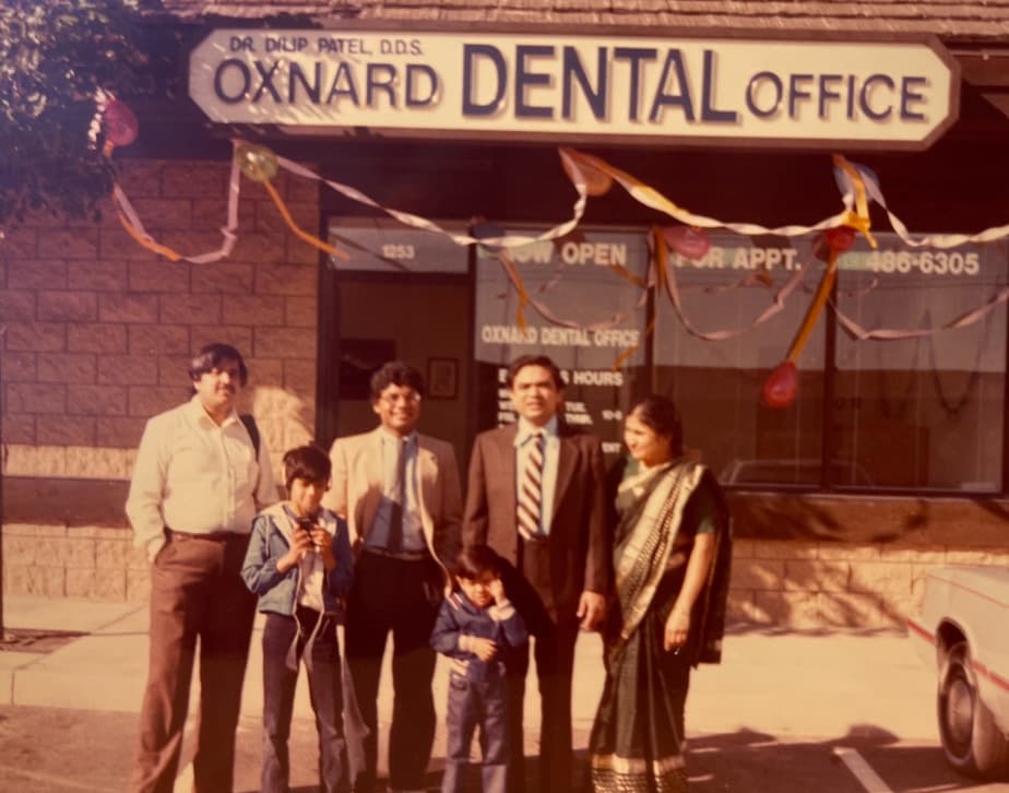 People gathered outside an earlier Oxnard Dental Office, under a sign reading Dr. Dilip Patel, D.D.S., with opening-day ribbons across the front. The door is numbered 1253.